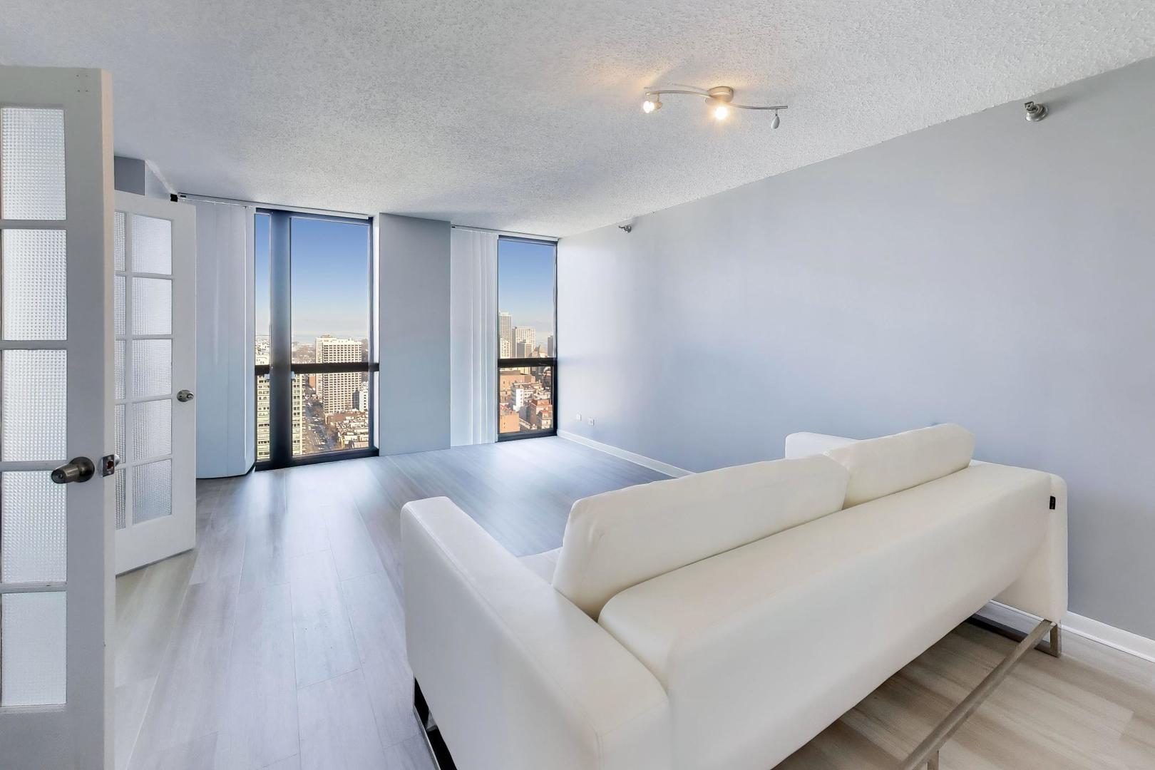 1122 North Clark Street, Unit 3705 Chicago, IL 60610 - Photo 13 of 38 a living room with furniture and a window