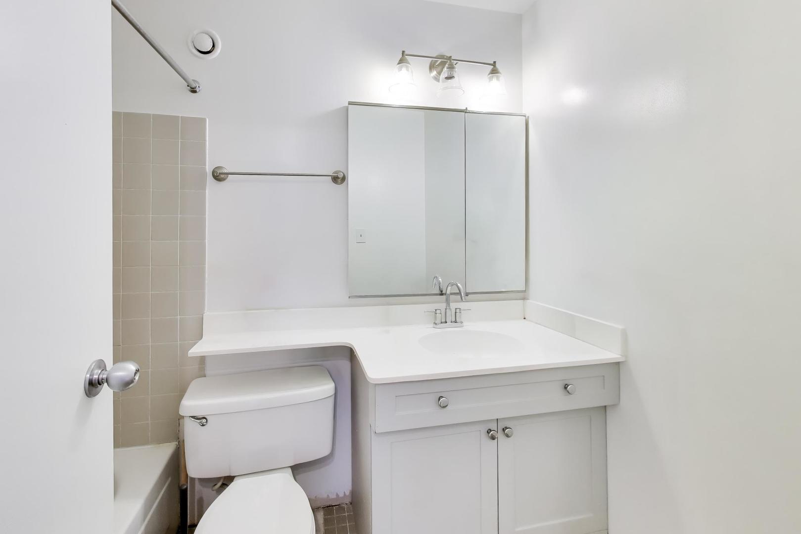 1122 North Clark Street, Unit 3705 Chicago, IL 60610 - Photo 19 of 38 a bathroom with a toilet sink and mirror