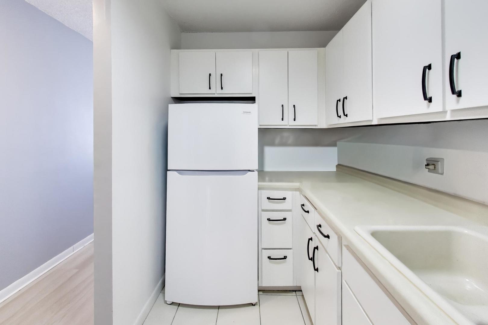 1122 North Clark Street, Unit 3705 Chicago, IL 60610 - Photo 9 of 38 a kitchen with white cabinets and refrigerator