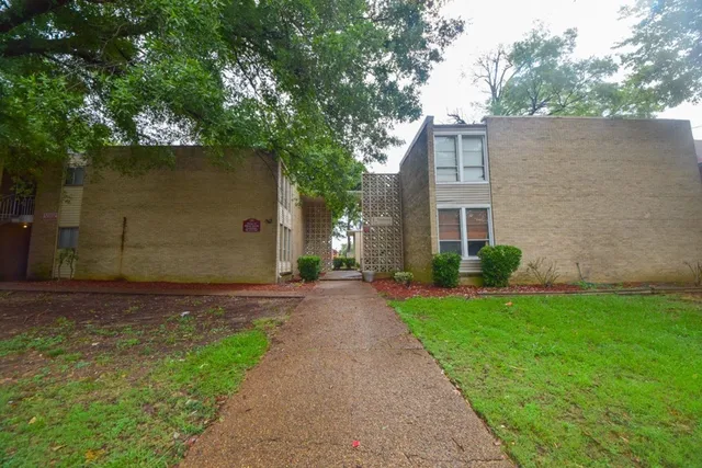 a pathway of a house with a yard