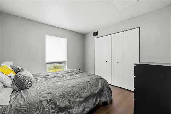 a bedroom with a bed and painting on the wall