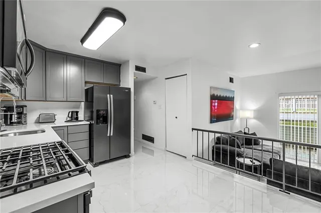 a kitchen with stainless steel appliances granite countertop a stove a sink and a microwave