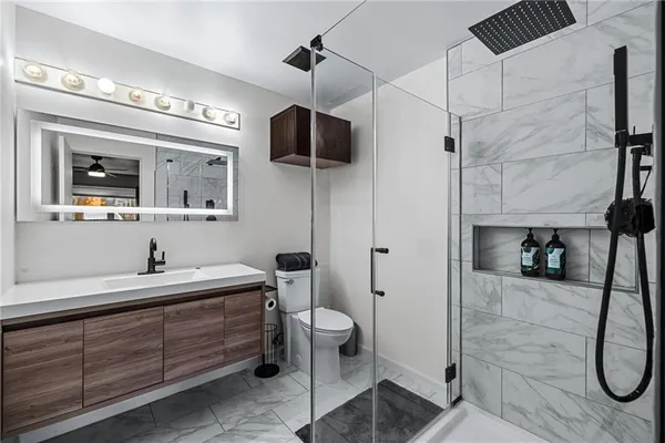 a bathroom with a sink a toilet and shower