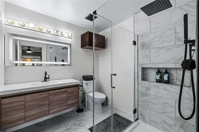 a bathroom with a sink a toilet and shower