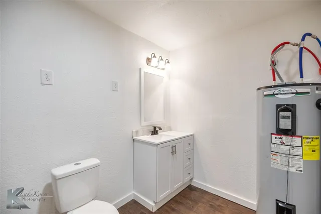 a bathroom with a sink toilet and a mirror