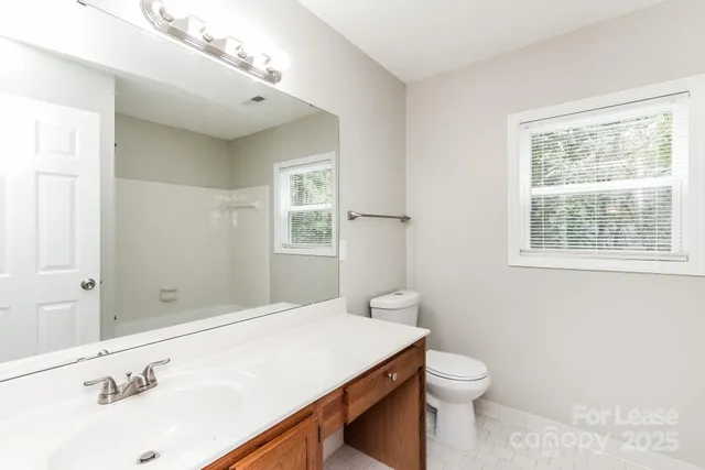 a bathroom with a sink a toilet and window