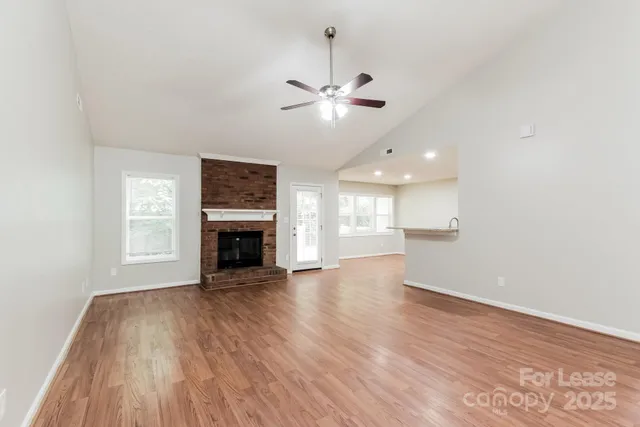 a view of an empty room with a window and fireplace