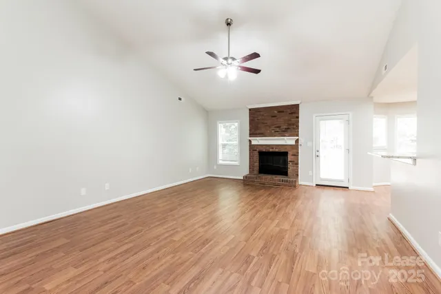 a view of empty room with wooden floor and fireplace