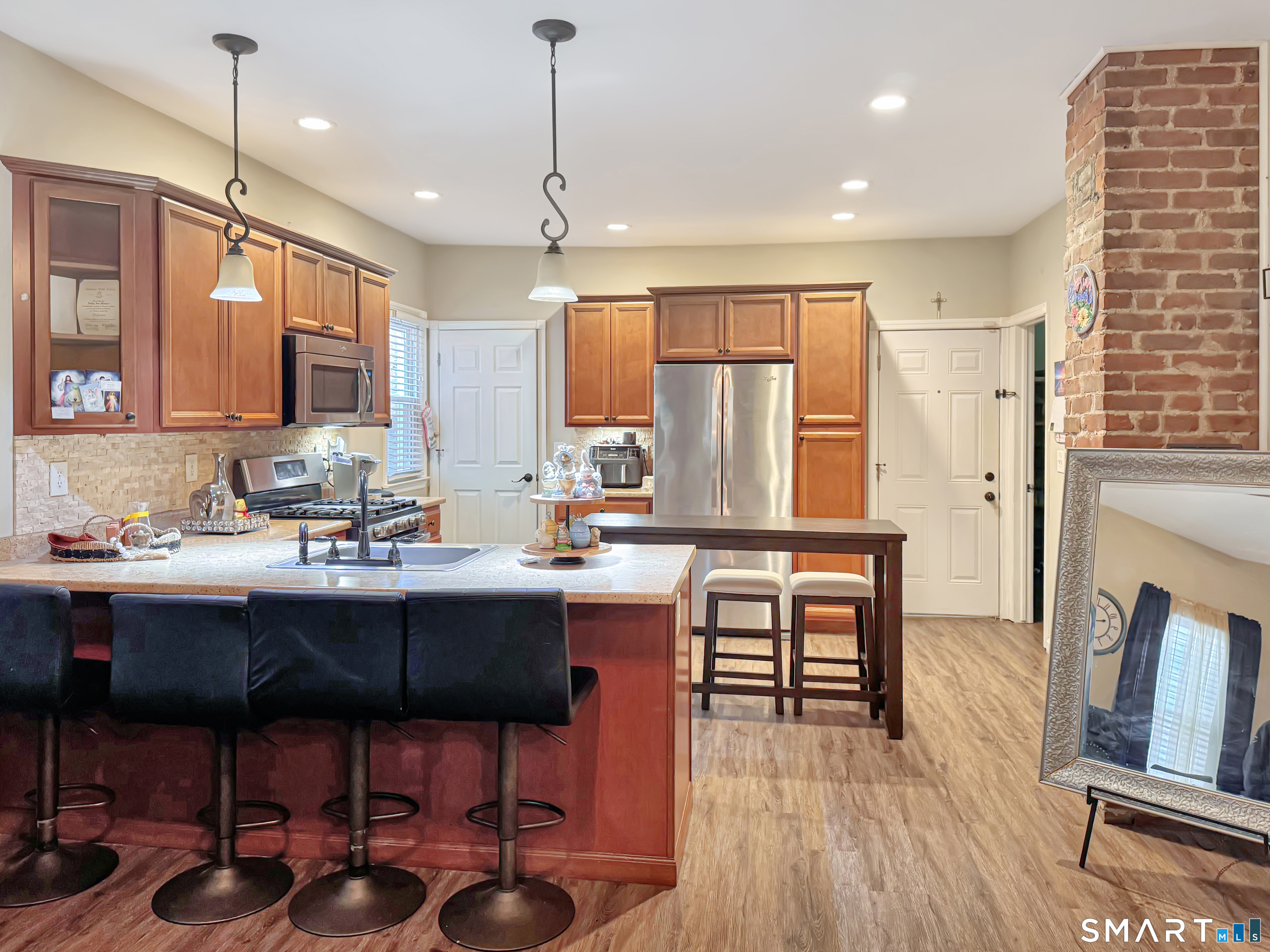 18 Columbia Street Ansonia, CT 06401 - Photo 7 of 16 a kitchen with stainless steel appliances a table chairs refrigerator and sink