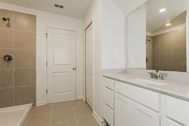 a bathroom with a granite countertop sink a shower and a mirror