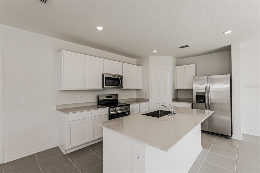 3526 Kimbrough Drive Lake Wales, FL 33853 - Photo 8 of 14 a kitchen with stainless steel appliances a microwave a sink a stove a refrigerator and white cabinets