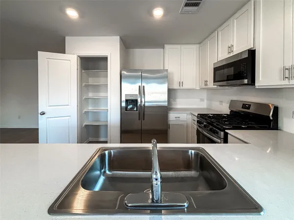 a kitchen with a sink and stainless steel appliances