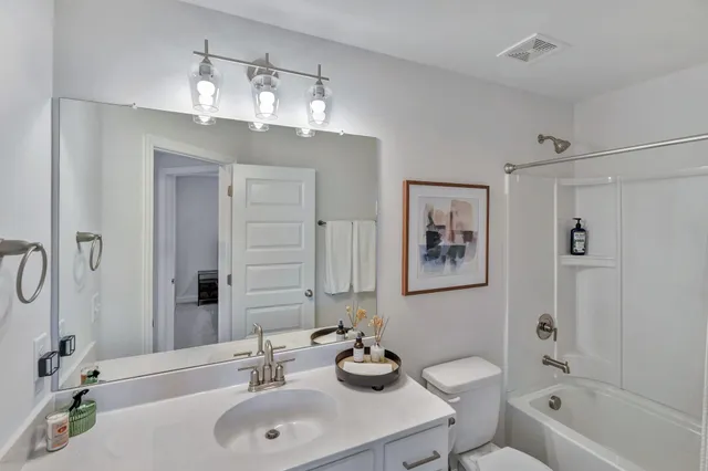 a bathroom with a bathtub shower sink and mirror