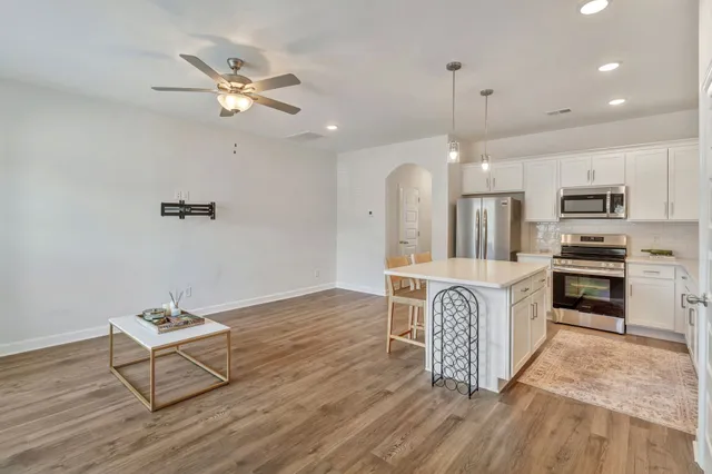 a kitchen with stainless steel appliances a dining table chairs stove and refrigerator