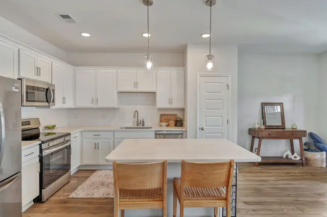 a kitchen with kitchen island a stove a table and chairs in it