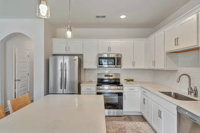 a kitchen with stainless steel appliances a refrigerator sink and cabinets