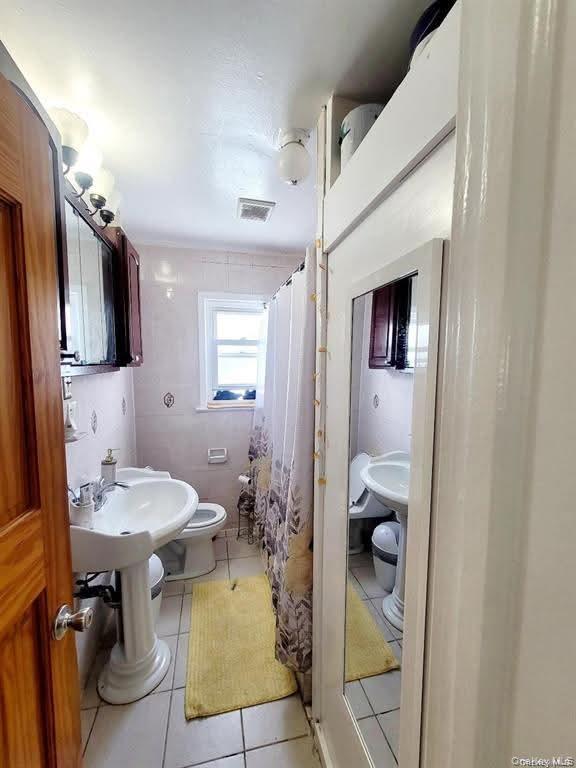 171-28 103rd Road Queens, NY 11433 - Photo 12 of 21 a bathroom with a sink a toilet and shower