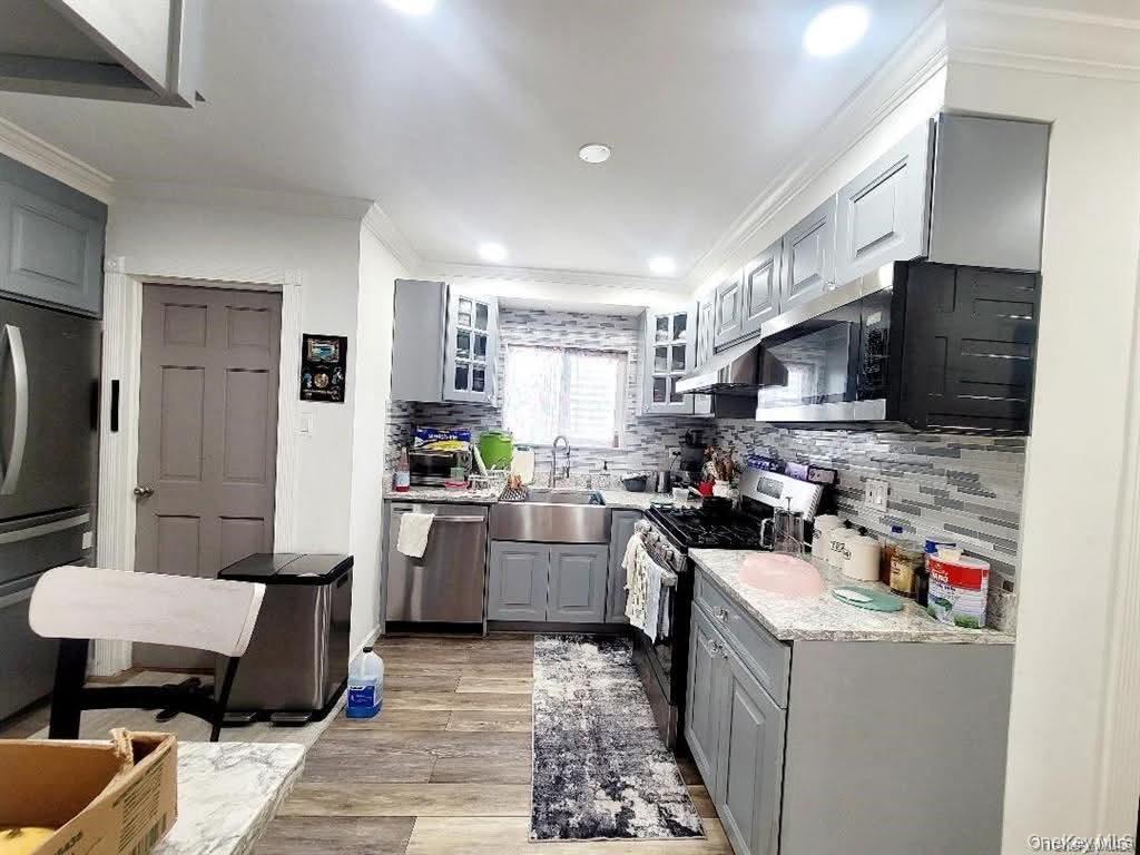 171-28 103rd Road Queens, NY 11433 - Photo 3 of 21 a kitchen with a sink dishwasher stove and refrigerator