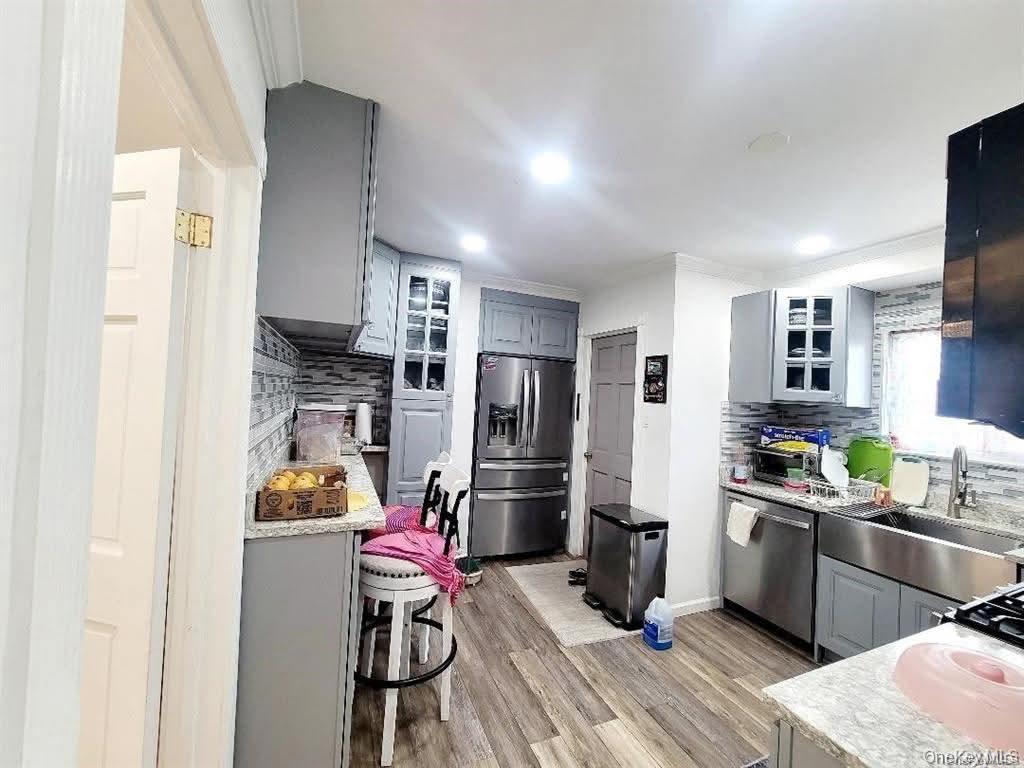171-28 103rd Road Queens, NY 11433 - Photo 4 of 21 a kitchen view with stainless steel appliances a refrigerator a sink a stove and cabinets