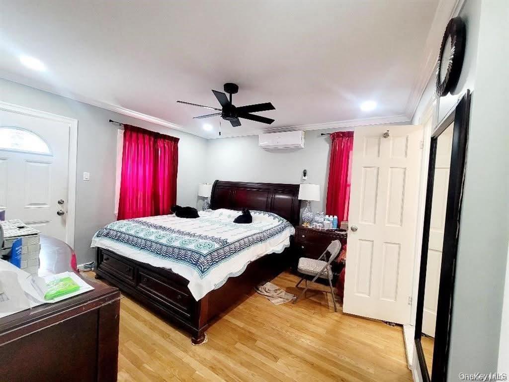 171-28 103rd Road Queens, NY 11433 - Photo 6 of 21 a bedroom with a bed and a dresser with mirror