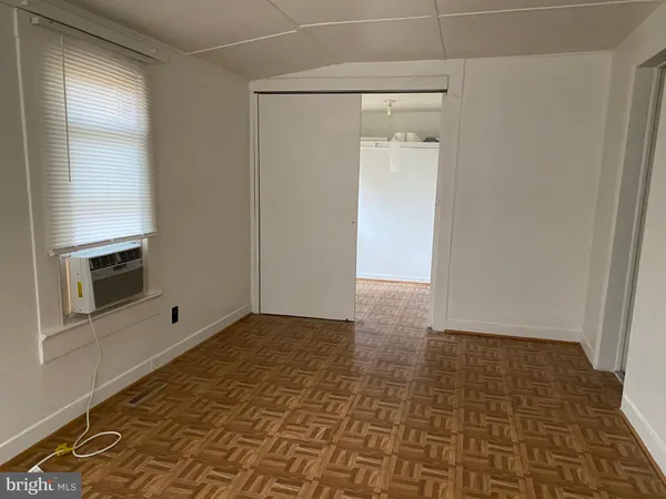 a view of empty room with a fireplace and wooden floor