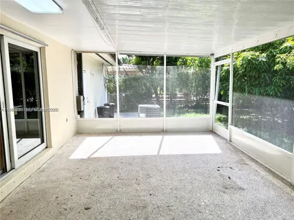 a view of an empty room with a sliding door and wooden floor