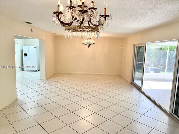 en empty room with a large window and chandelier