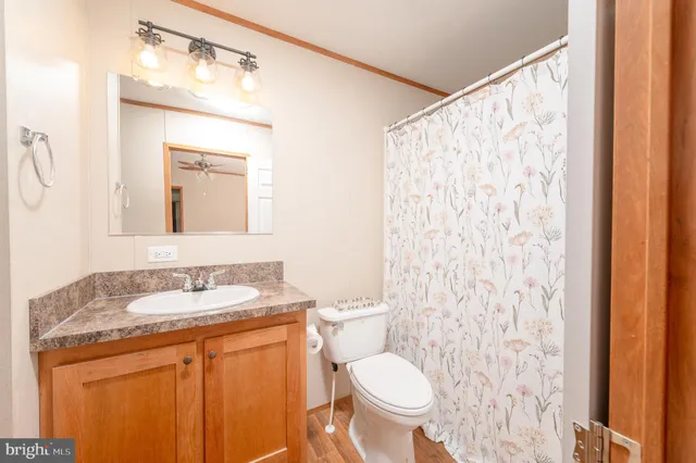 a bathroom with a granite countertop sink toilet and mirror