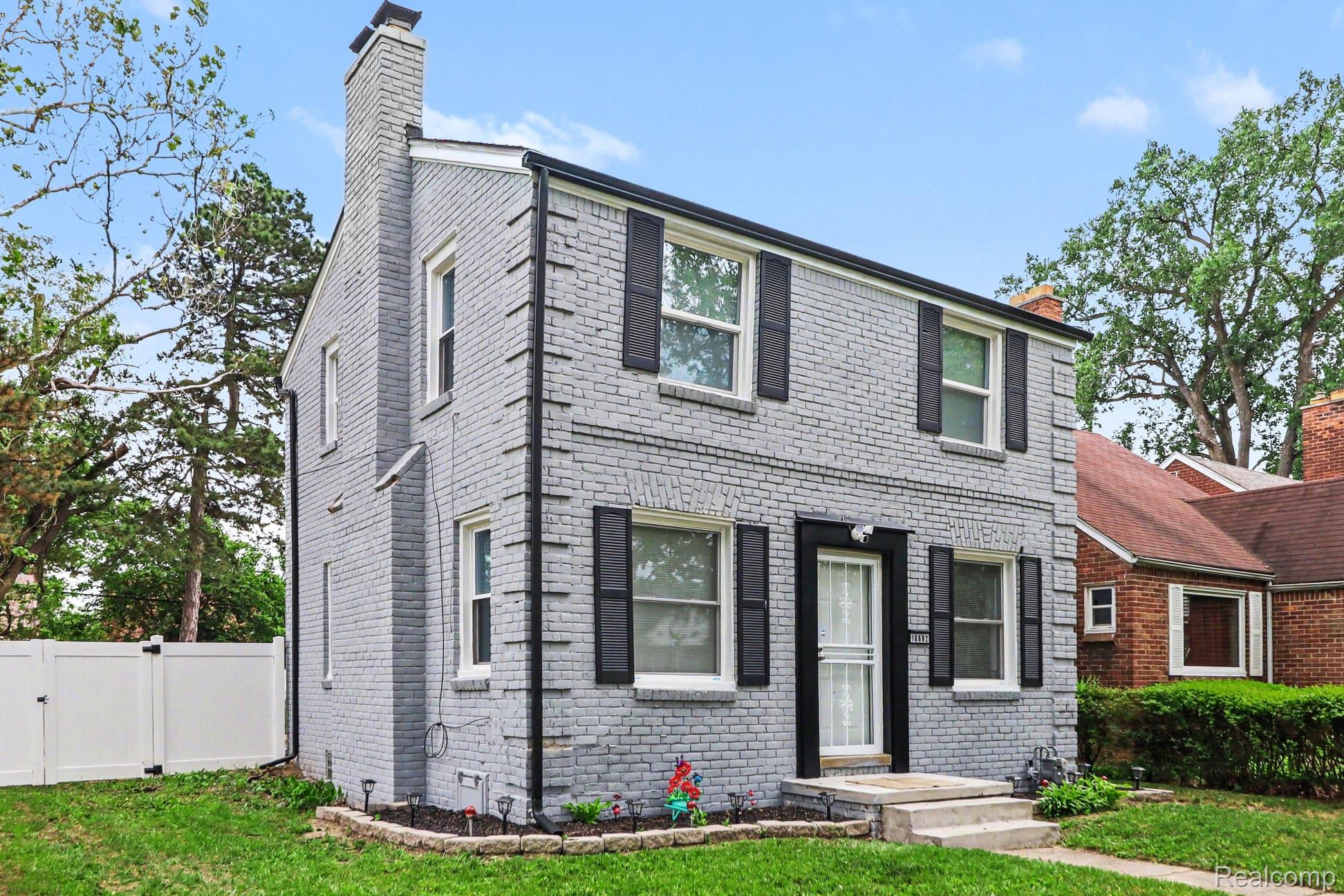 16682 Robson Street Detroit, MI 48235 - Photo 4 of 19 Two-story brick residence with a painted gray finish and a prominent chimney feature
