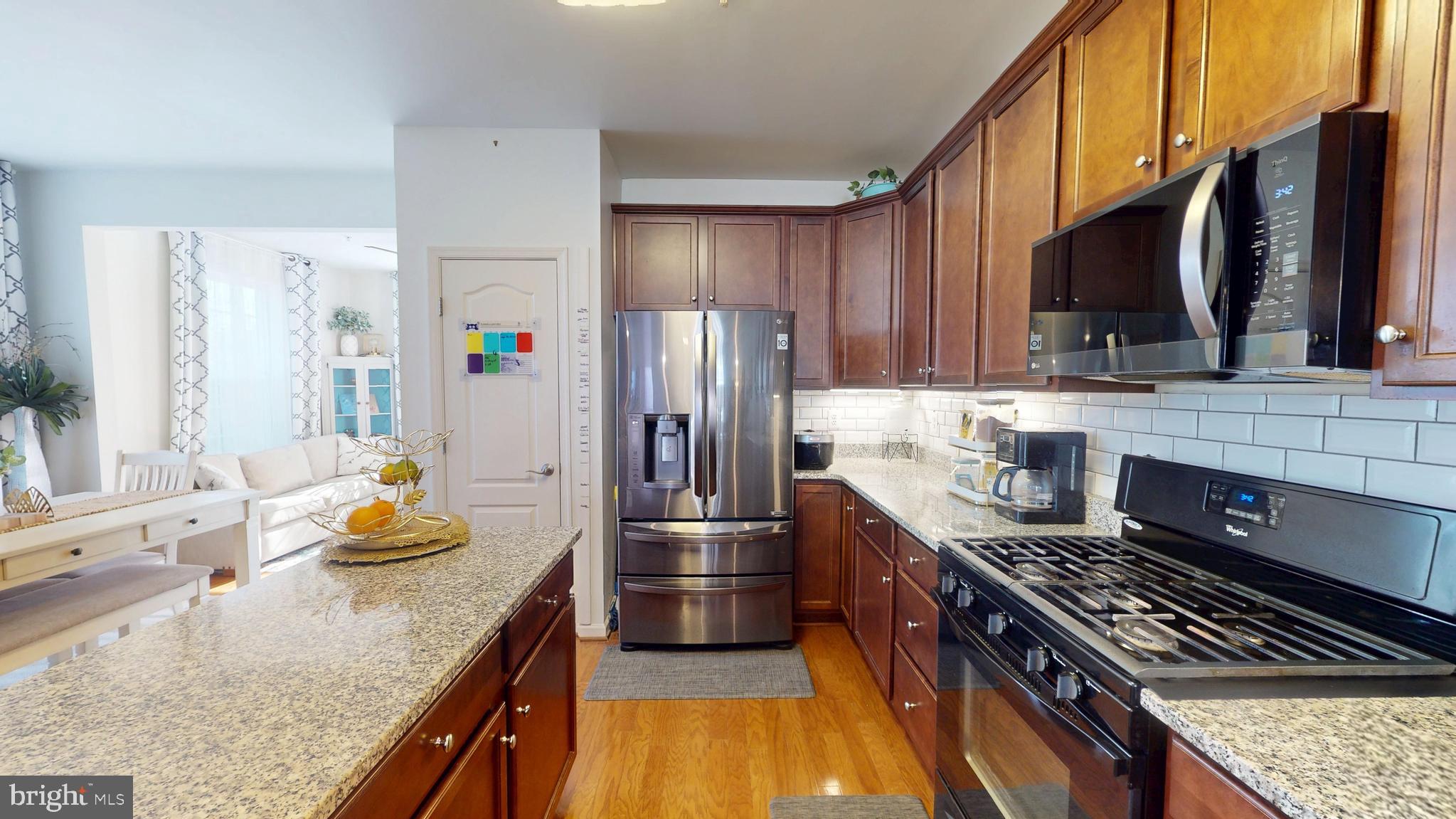 8548 Golden Eagle Lane Severn, MD 21144 - Photo 14 of 76 a kitchen with stainless steel appliances granite countertop a sink stove and refrigerator