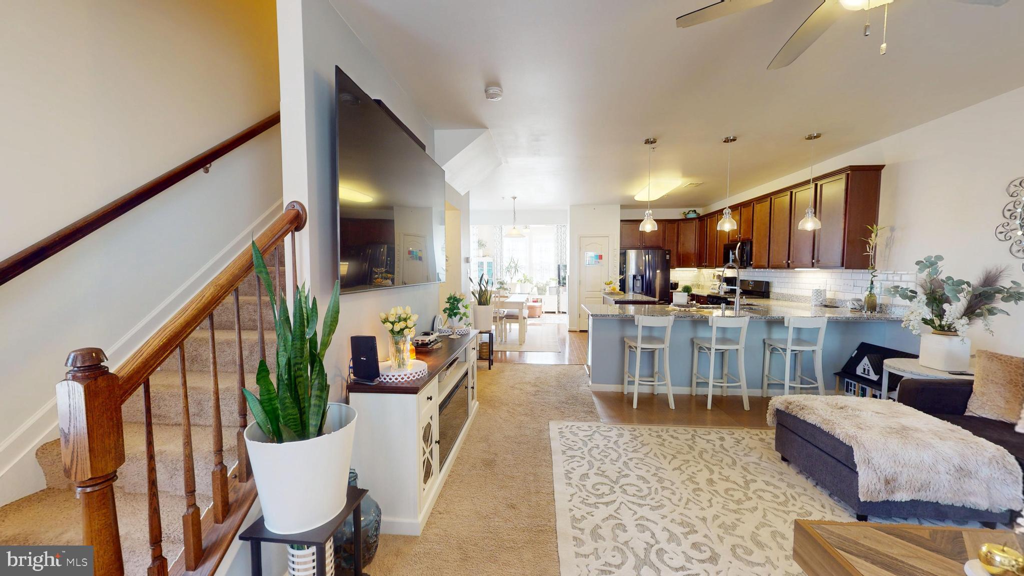 8548 Golden Eagle Lane Severn, MD 21144 - Photo 29 of 76 a living room with stainless steel appliances kitchen island granite countertop wooden floor a couch and a view of kitchen