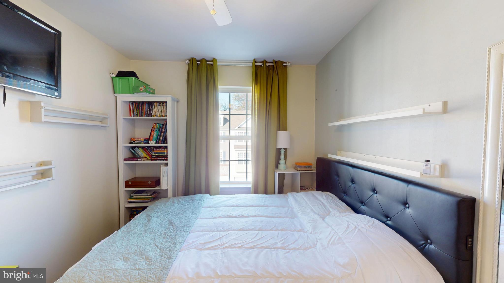 8548 Golden Eagle Lane Severn, MD 21144 - Photo 51 of 76 a bedroom with a bed and a flat tv screen in a bedroom