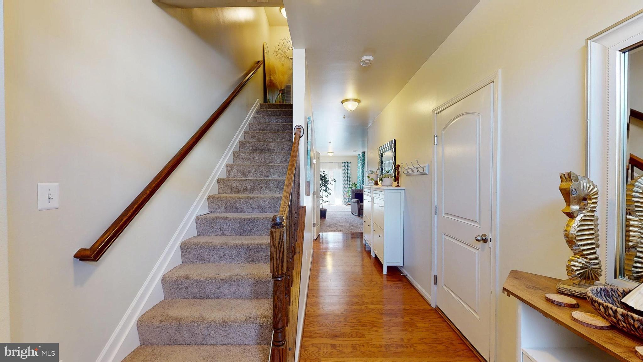 8548 Golden Eagle Lane Severn, MD 21144 - Photo 6 of 76 a view of a hallway with wooden floor and staircase