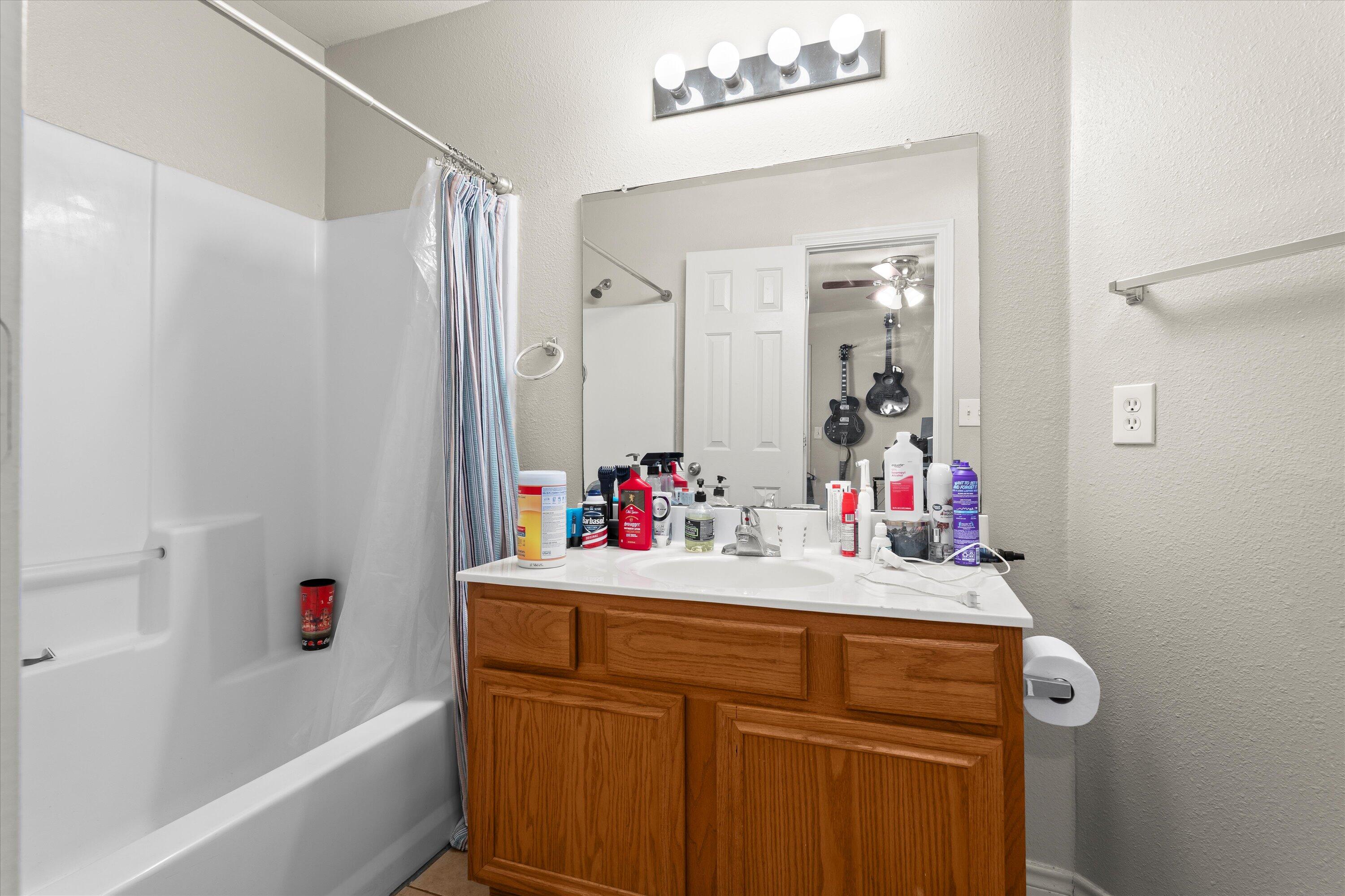 5423 Marshall Street Lubbock, TX 79416 - Photo 18 of 25 a bathroom with a sink vanity tub and shower