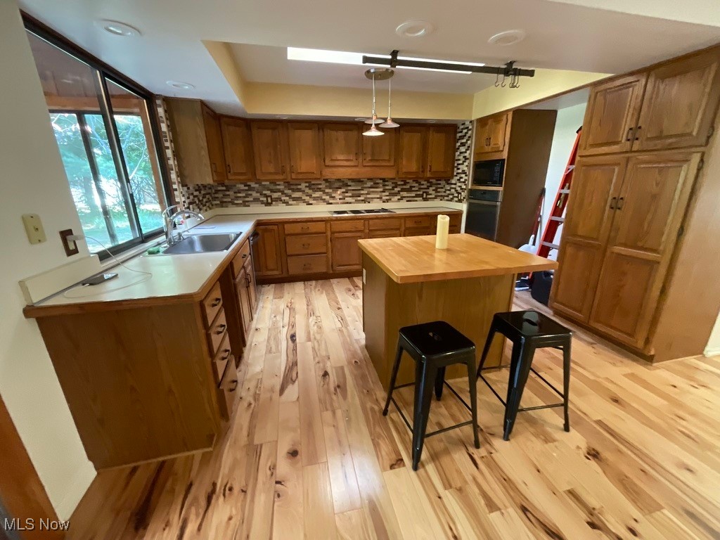 11331 Palmer Road Painesville, OH 44077 - Photo 8 of 47 Kitchen featuring wooden counters, light wood-type flooring, oven, backsplash, and a center island