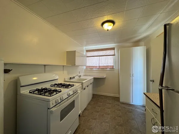 a kitchen with a stove a refrigerator and a sink