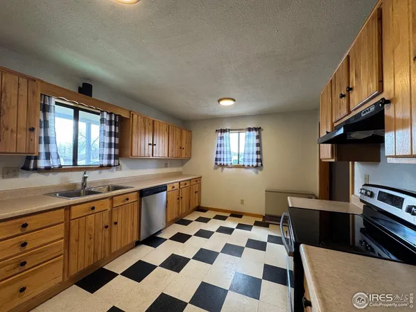 a kitchen with a sink a stove cabinets and a window