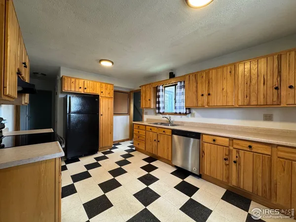 a kitchen with a checkered floor and white cabinets