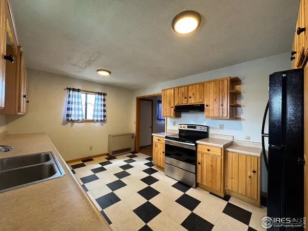 a kitchen with granite countertop stainless steel appliances a stove a sink and a refrigerator