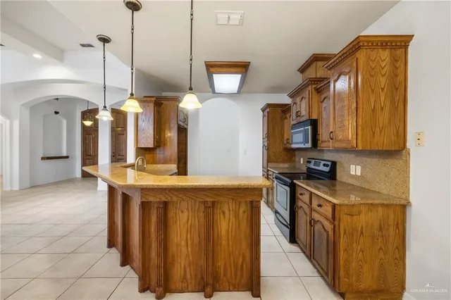 a kitchen with stainless steel appliances granite countertop a sink and a refrigerator