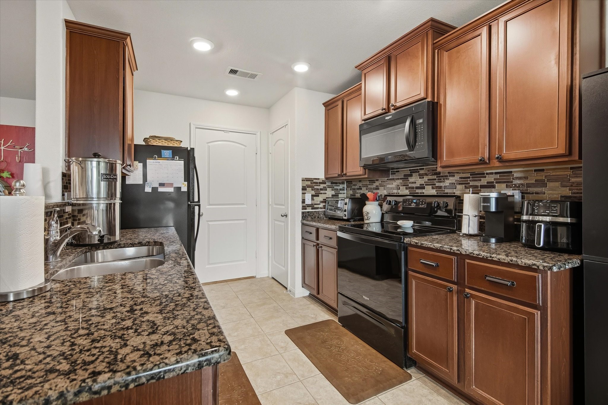 1306 Paradise Found Drive Rosharon, TX 77583 - Photo 17 of 36 a kitchen with stainless steel appliances granite countertop a stove oven and a refrigerator