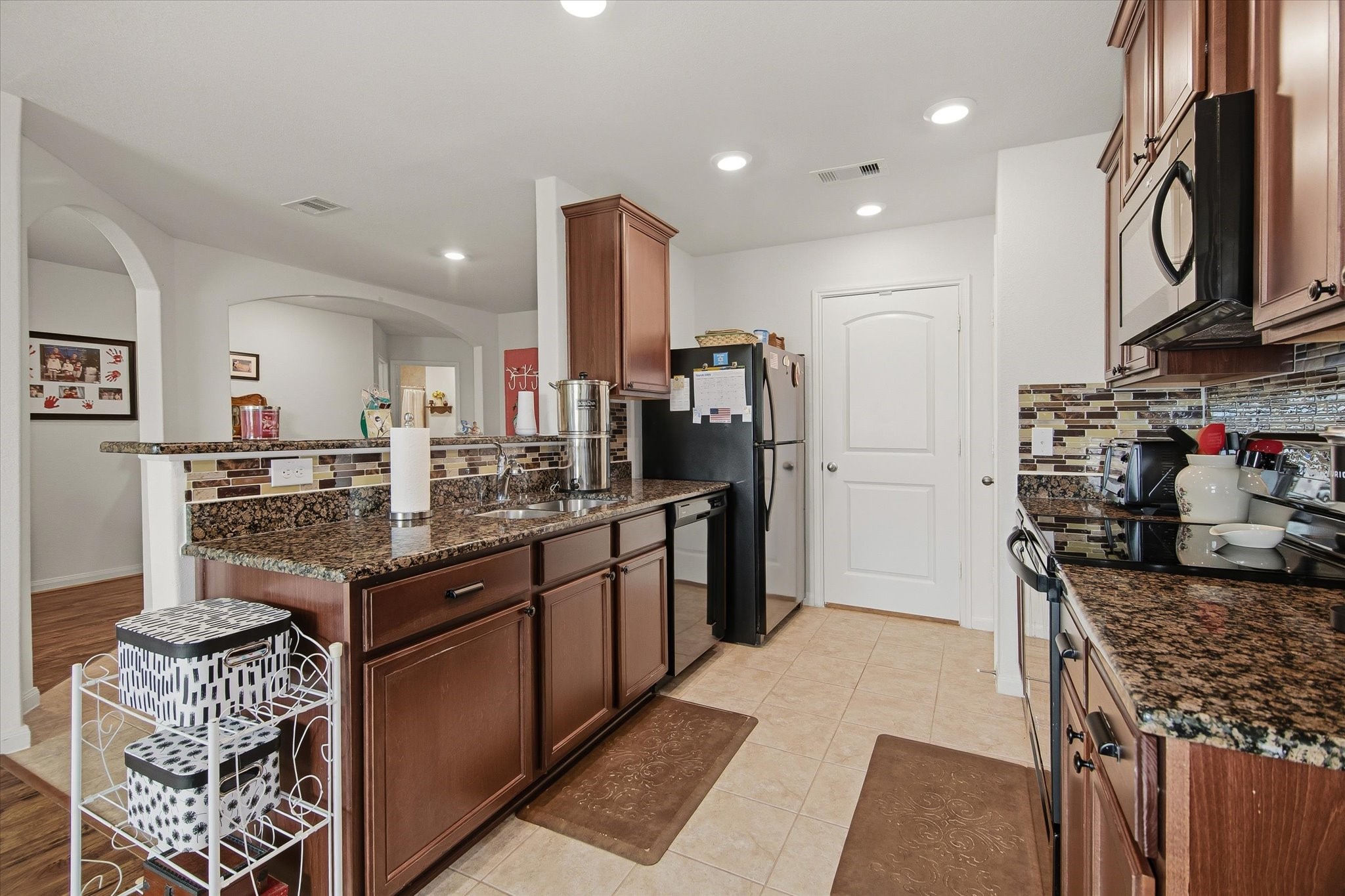 1306 Paradise Found Drive Rosharon, TX 77583 - Photo 18 of 36 a kitchen with stainless steel appliances granite countertop a sink stove and refrigerator