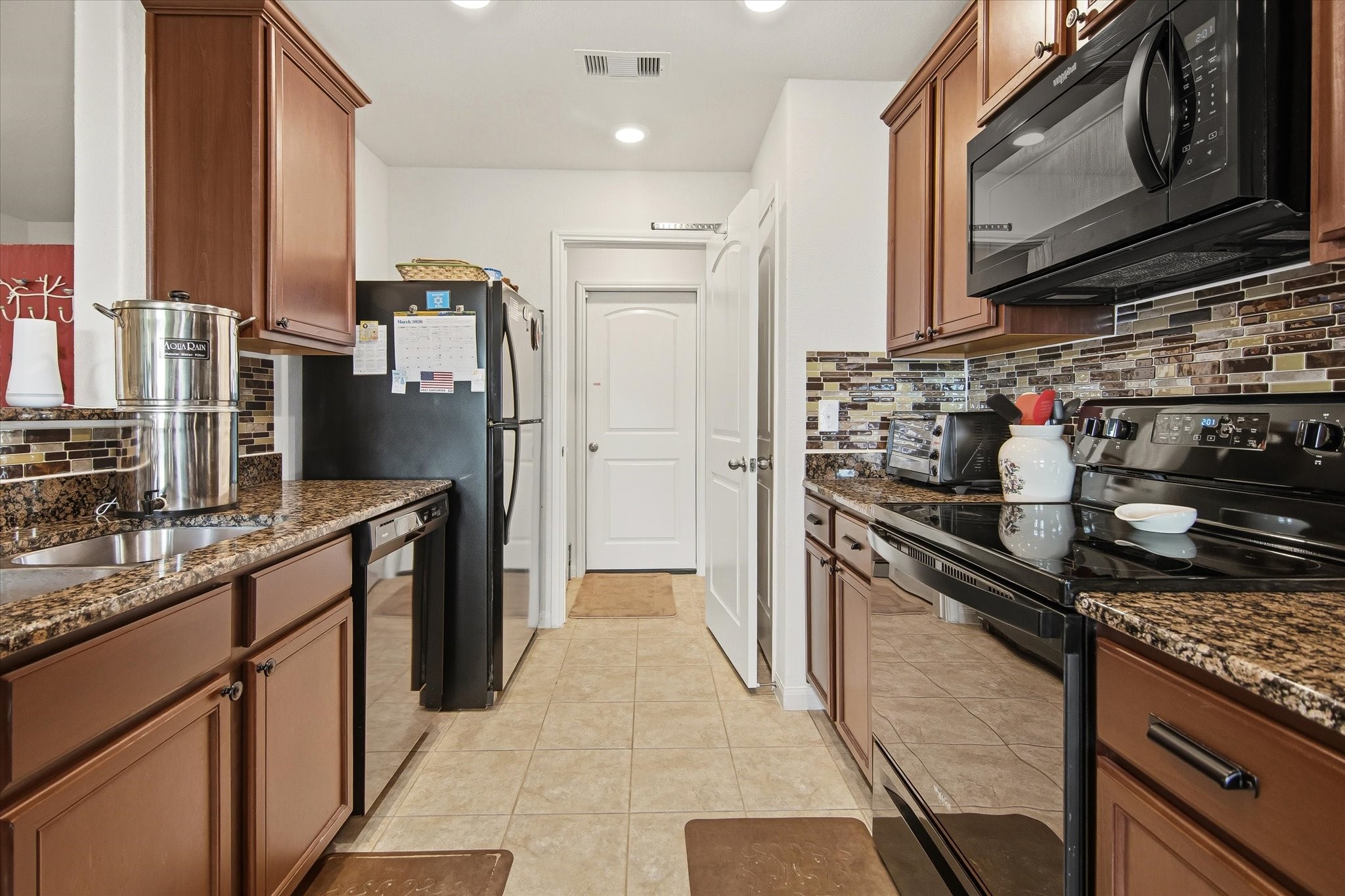1306 Paradise Found Drive Rosharon, TX 77583 - Photo 21 of 36 a kitchen with stainless steel appliances granite countertop a refrigerator stove and sink