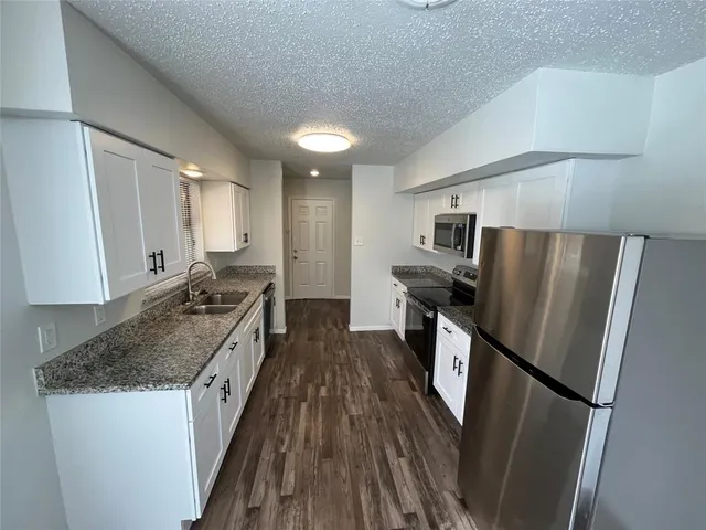 a kitchen with stainless steel appliances granite countertop a refrigerator stove and sink