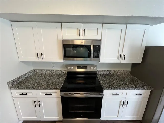 a kitchen with granite countertop a stove and a sink