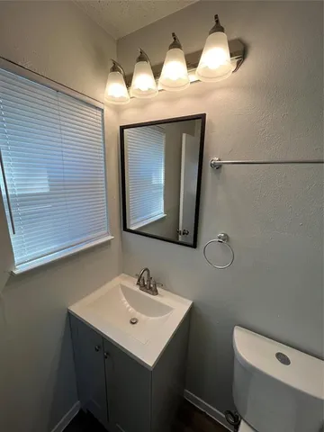 a bathroom with a sink mirror vanity and toilet