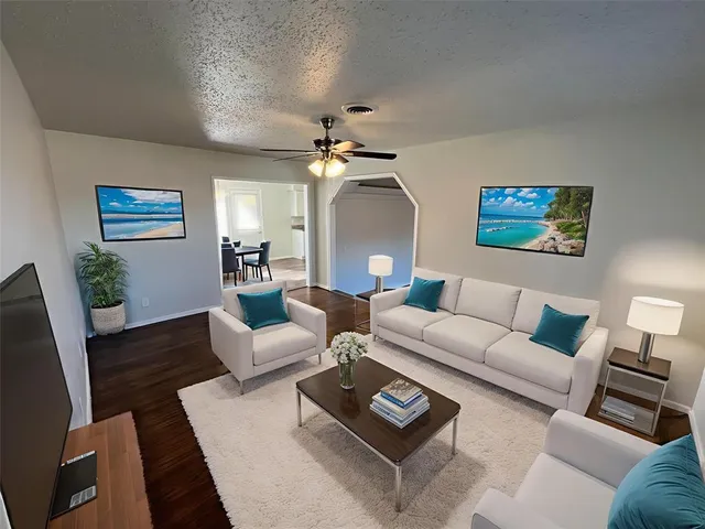 a living room with furniture a bed and a painting on the wall