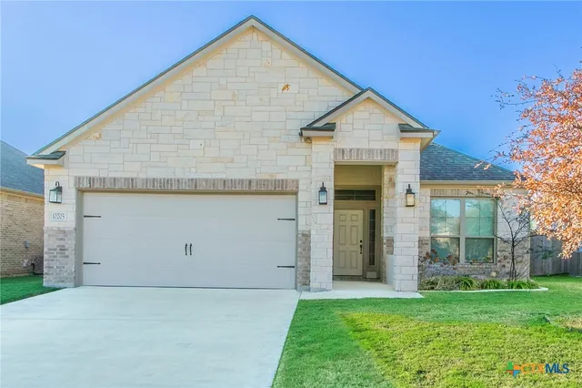 a view of a house with a yard and garage