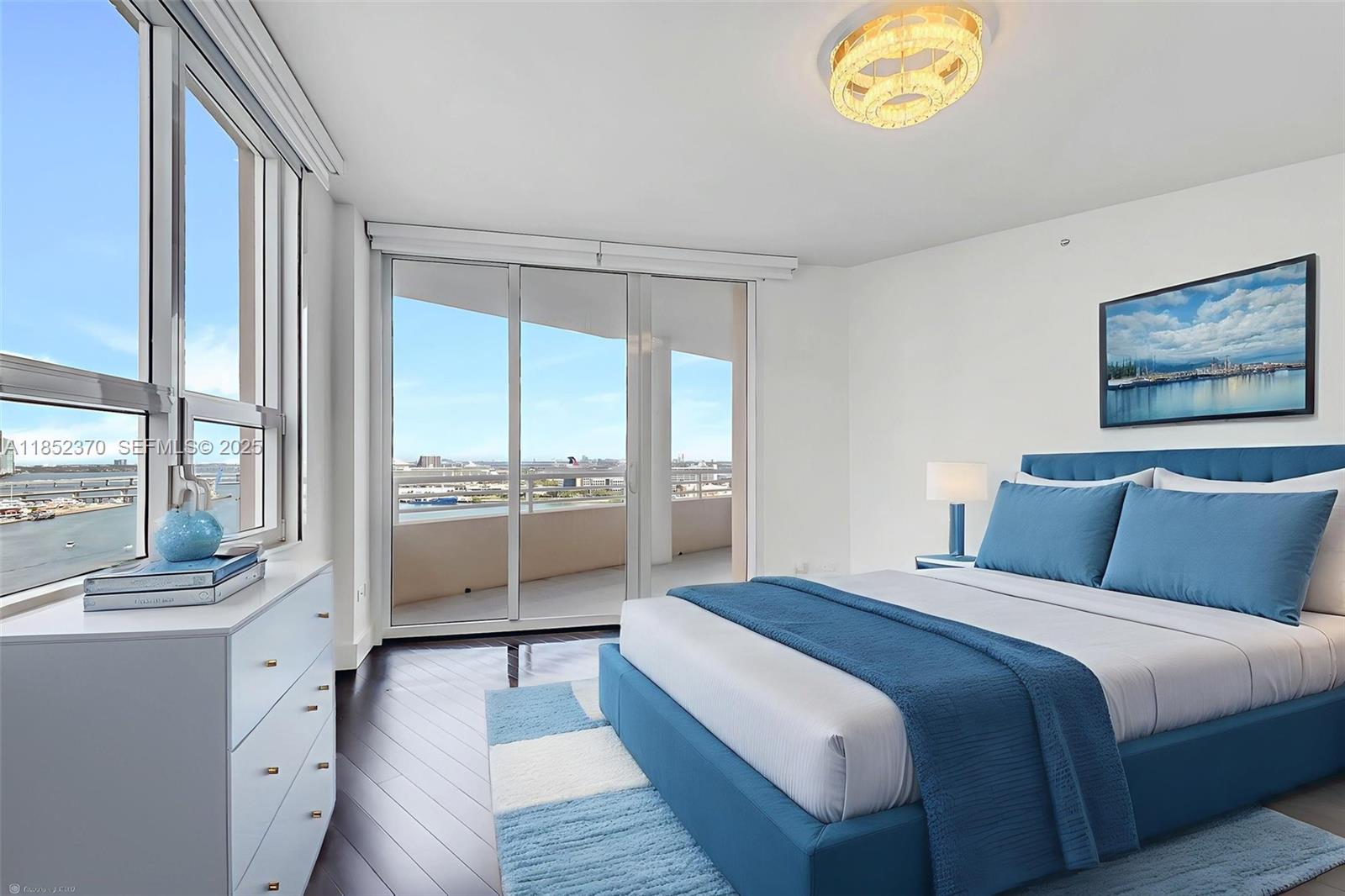 848 Brickell Key Drive, Unit 1906 Miami, FL 33131 - Photo 12 of 18 a bedroom with a balcony a bed and a view of living room