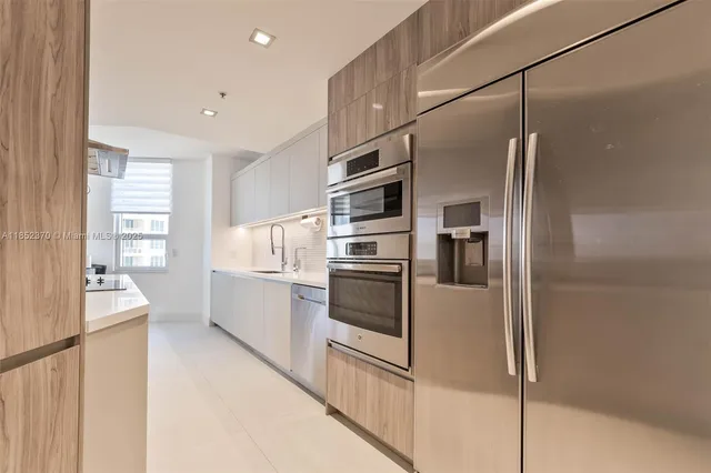 a kitchen with stainless steel appliances a refrigerator and a stove top oven